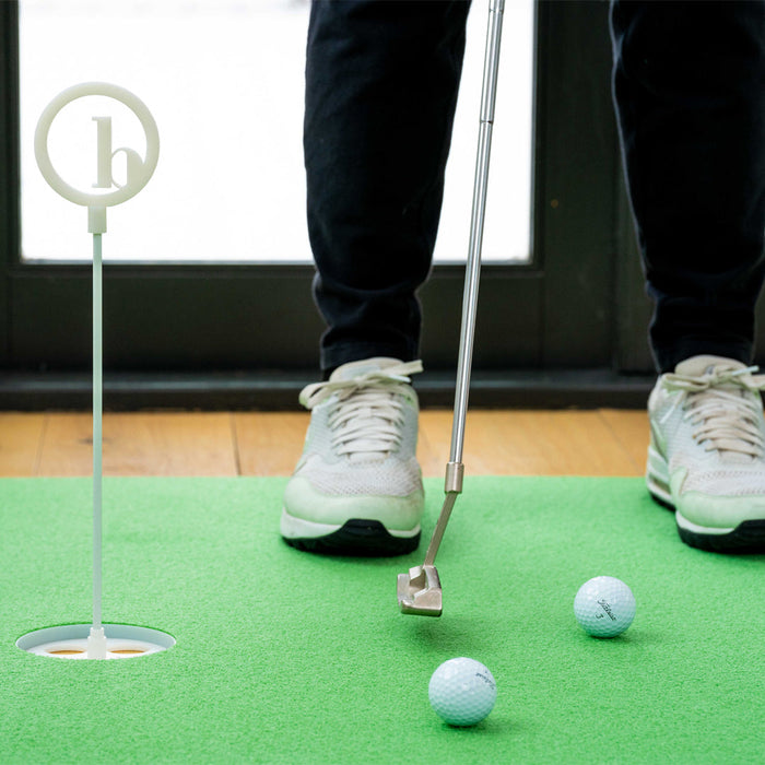 putter being used on tour turf indoor putting mat